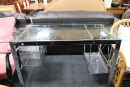 A steel framed and glass topped desk