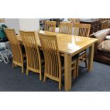 A contemporary oak extending dining table with leaf together with a set of six rail back chairs