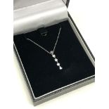 A 10ct gold three stone diamond pendant on chain