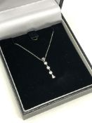 A 10ct gold three stone diamond pendant on chain