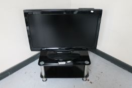 A Sharp Aquos 32" LCD TV with remote on stand