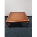 A square mahogany coffee table on claw and ball feet