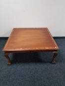 A square mahogany coffee table on claw and ball feet