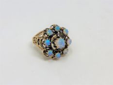 A 14ct gold opal ring, the nine cabochon Australian opals weighing 5.02 carats in total, size L.