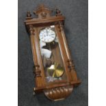An antique mahogany cased wall clock with pendulum,