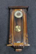 An antique mahogany cased Vienna wall clock, with pendulum,