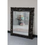 An antique carved oak framed overmantel mirror