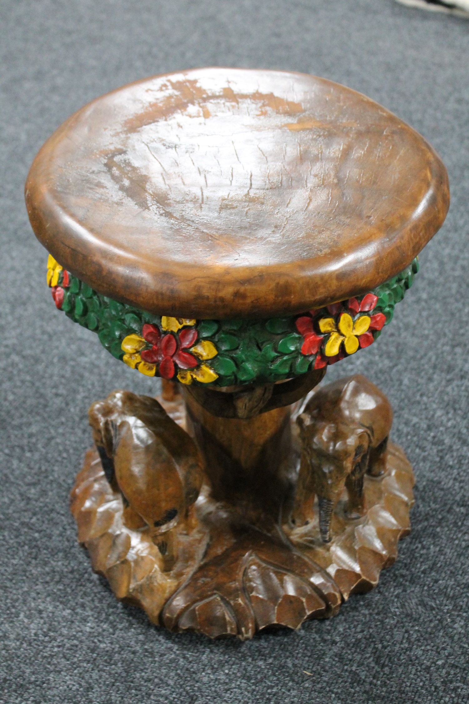 A carved hardwood and painted elephant stool