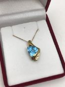 A 10ct gold topaz and diamond pendant