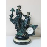 A continental style resin figural mantel timepiece