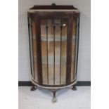 An antique mahogany D-shaped display cabinet on claw and ball feet