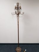 A decorative metal six way floor lamp with glass drops