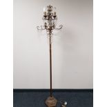 A decorative metal six way floor lamp with glass drops