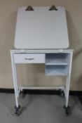 A metal medical trolley fitted a drawer,