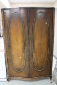 A walnut bow fronted double door wardrobe