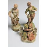 A pair of Royal Dux figures of water carriers together with another of two seated children
