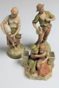 A pair of Royal Dux figures of water carriers together with another of two seated children