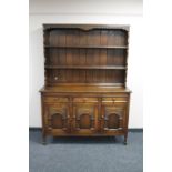 A carved oak triple door kitchen dresser