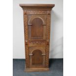 An early 20th century continental carved oak sentry door cabinet