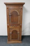 An early 20th century continental carved oak sentry door cabinet