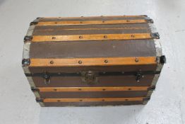 An early 20th century wooden bound dome topped travelling trunk