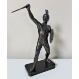 A metal figure of a warrior on plinth