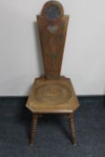 A carved oak spinning chair on bobbin legs