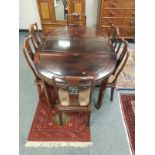 A Chinese hardwood extending dining table and matching set of six chairs.