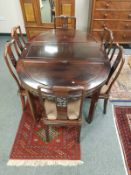 A Chinese hardwood extending dining table and matching set of six chairs.