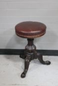 A circular Victorian adjustable stool on tripod base