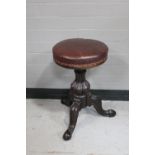 A circular Victorian adjustable stool on tripod base