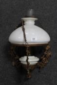 An antique hanging oil lamp with chimney and glass shade