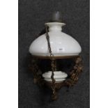 An antique hanging oil lamp with chimney and glass shade