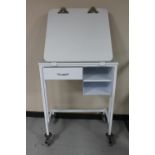 A metal medical trolley fitted a drawer,