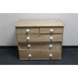 A Victorian pine five drawer chest with white porcelain handles