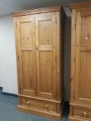 A contemporary pine double door wardrobe fitted a drawer,