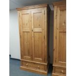 A contemporary pine double door wardrobe fitted a drawer,