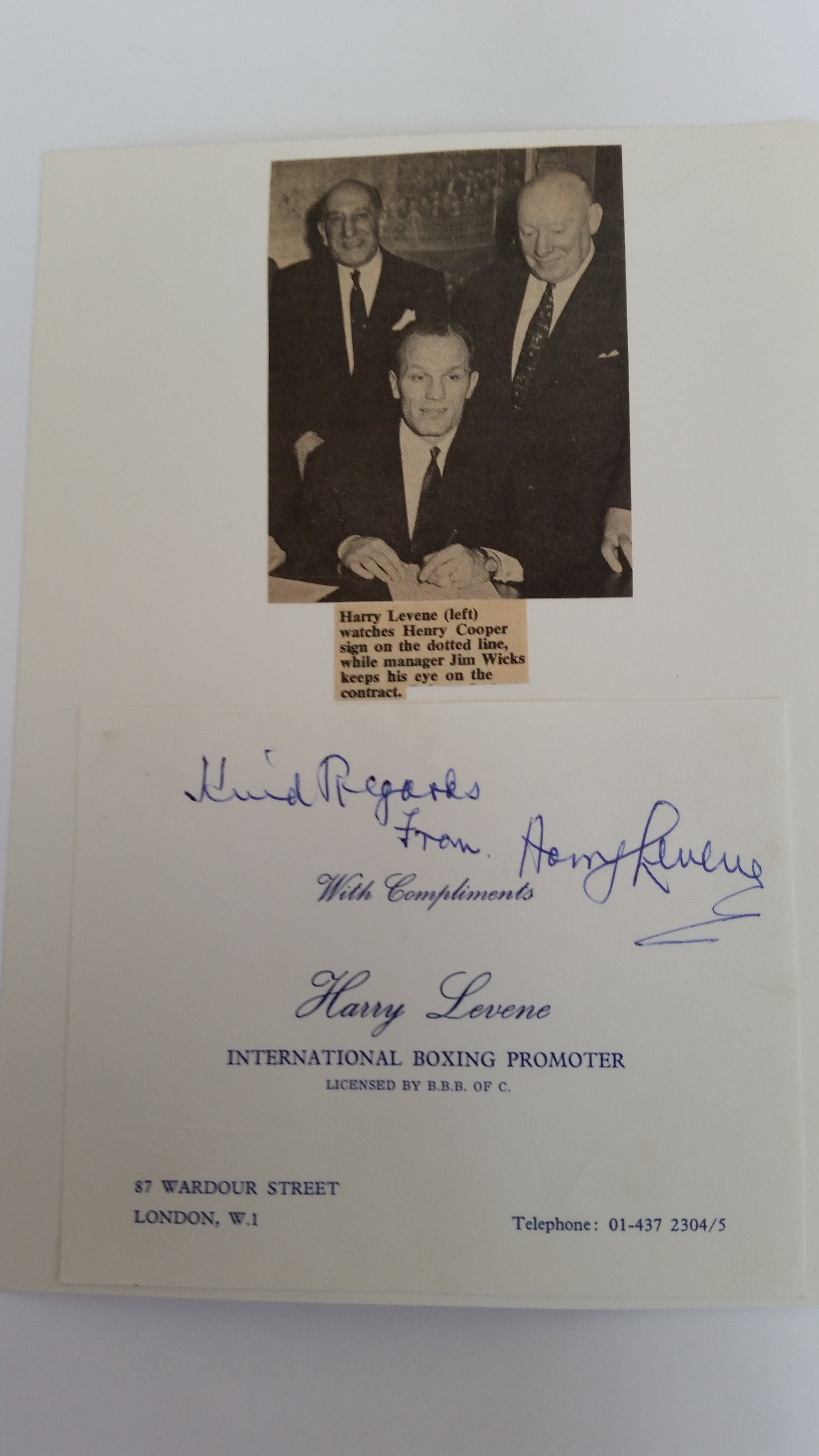 BOXING, signed compliment slip by Harry Levene, laid down to card beneath photo showing him watching