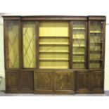 A large 19th century mahogany inverted breakfront library bookcase, the moulded pediment above