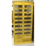 An Art Deco oak haberdashery cabinet by Dudley & Co Ltd, London, fitted with twenty glazed and solid