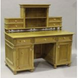 An early 20th century Continental pine twin pedestal desk, the shelf back with four drawers above
