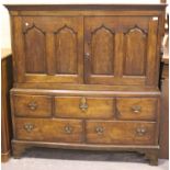 An 18th century oak livery cupboard, the moulded pediment above a pair of arch panelled doors and an