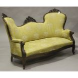 A 19th century French mahogany showframe salon settee with carved decoration, upholstered in