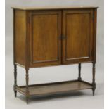 A late Victorian side cabinet, enclosed by two panelled doors, on turned and block legs united by an