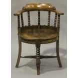 A late Victorian walnut tub back chair with bobbin turned supports, the solid seat on outswept legs,