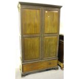 A George V mahogany wardrobe by Druce & Co, London, the dentil pediment above two panelled doors and