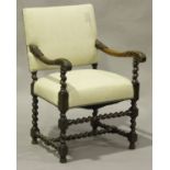 A 19th century Carolean Revival walnut open armchair with carved decoration, the upholstered seat