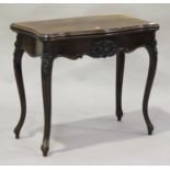 A Victorian mahogany fold-over card table, the frieze carved with leaf and flower decoration, the