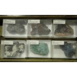 A selection of mineral specimens, all contained within an oak chest of drawers, including
