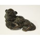 A Chinese carved bamboo figure of a Buddhistic lion, Qing dynasty, finely modelled in a recumbent